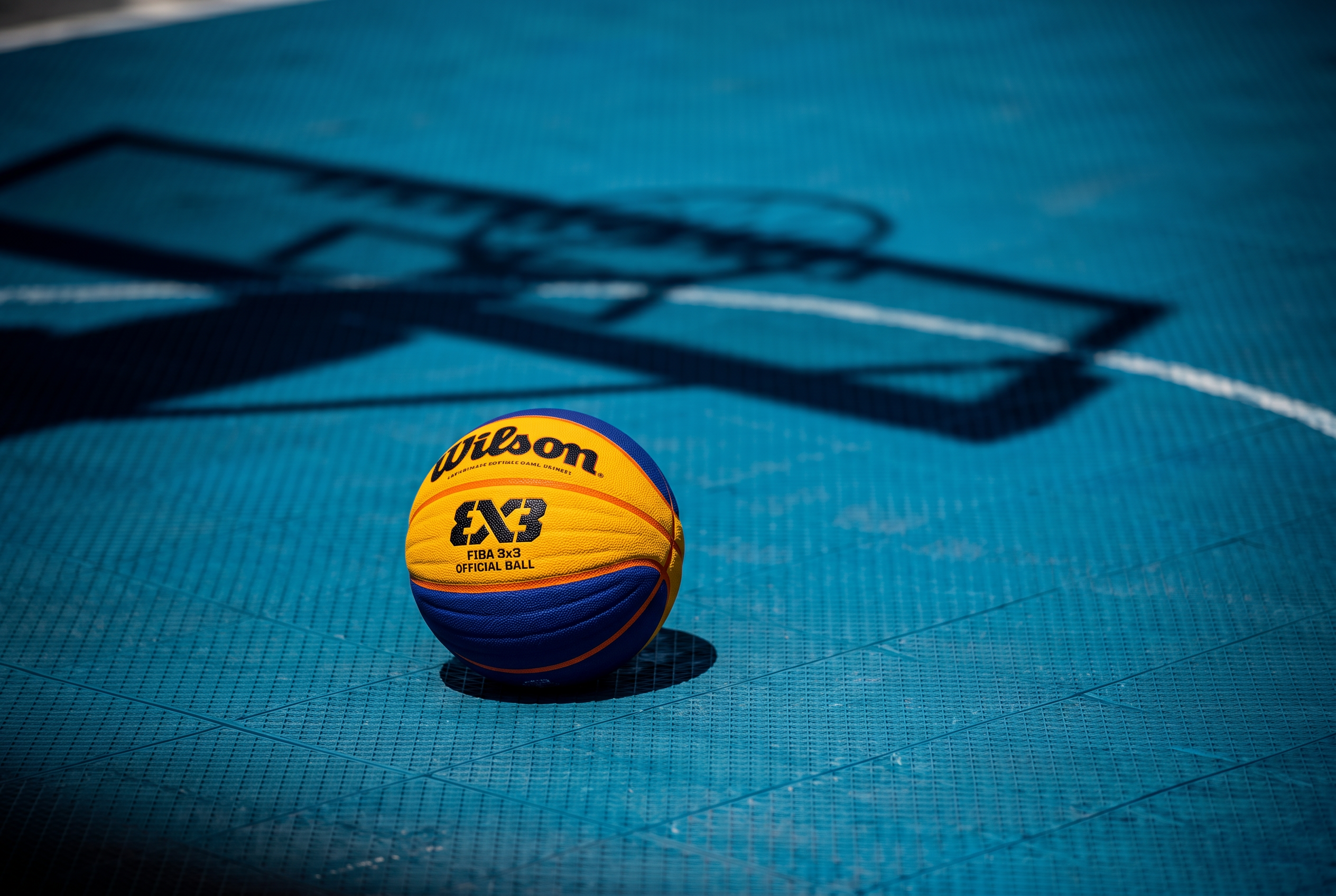 Official Wilson FIBA 3x3 basketball on a blue outdoor court