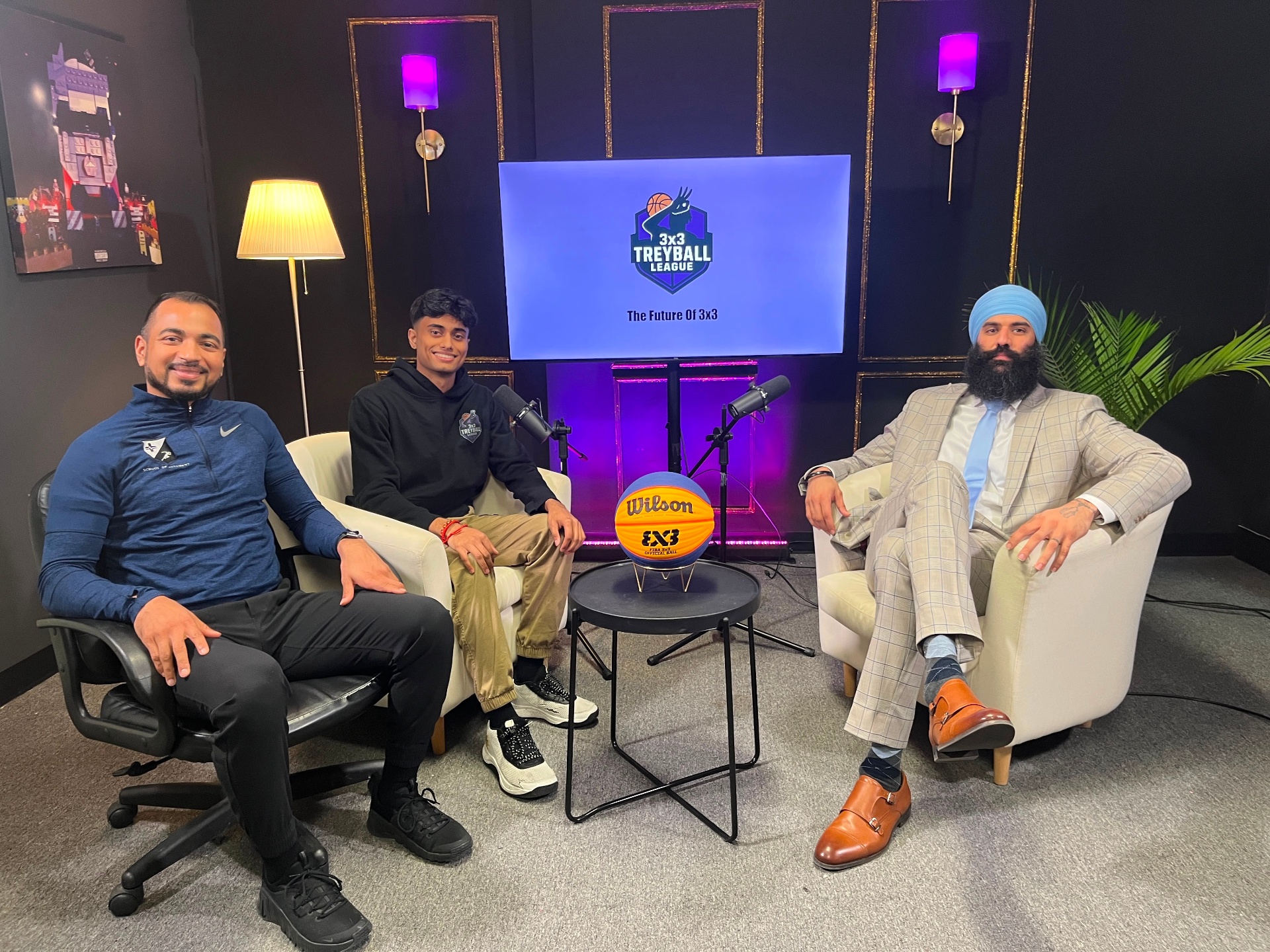 The Treyball Pod hosts on set — three hosts seated around a Wilson FIBA 3x3 ball with the 3x3 Treyball League screen behind them